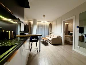 a kitchen and living room with a table and a couch at Blue Reef 6th Floor Sea View in Międzyzdroje
