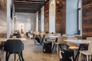 a restaurant with tables and chairs and wooden walls at B&B Hotel Passo Tre Croci Cortina in Cortina dʼAmpezzo