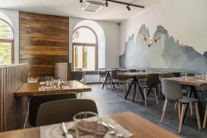 a dining room with tables and chairs and a mural at B&B Hotel Passo Tre Croci Cortina in Cortina dʼAmpezzo