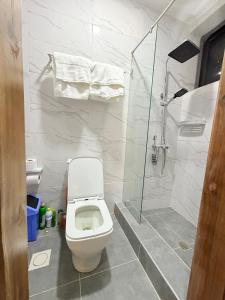 ein weißes Badezimmer mit Toilette und Dusche in der Unterkunft A Serene home away from home in Damba + 13 Fotos