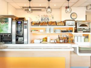 eine Küche mit einer Theke und einem Kühlschrank in der Unterkunft ibis budget Mâcon Nord in Mâcon + 11 Fotos