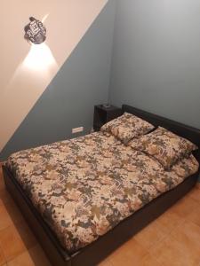 une chambre avec un lit avec un couvre-lit fleuri dans l'établissement nanouche, à Brignoles