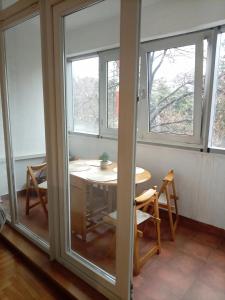 ein Raum mit einem Tisch und zwei Fenstern in der Unterkunft Linda Apartments- Arena in Novi Beograd