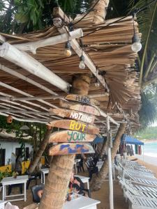 a sign that says nothing but your sign on a beach at Seasong Rooms in Unawatuna +2 photos