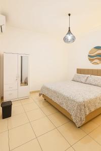 una camera da letto bianca con un letto e uno specchio di Villa Cempaka - Pemogan a Denpasar