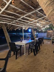 a dining room with a table and chairs on the beach at Seasong Rooms in Unawatuna