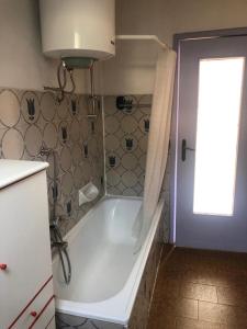 een badkamer met een wit bad en een raam bij Mansarda Panoramica nelle Valli di Lanzo Camino & Silenzio in Ceres