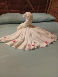a dress on a bed with roses on it at El Hermosa Bice Camp in El Nido