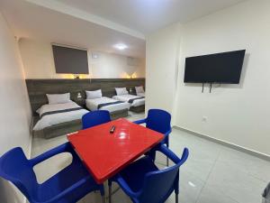 a room with a red table and blue chairs at Happy Beach Castel for Apartment قلعة شاطئ السعادة للشقق المفروشة in Aqaba