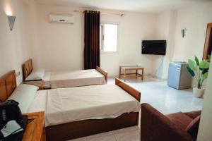 a hotel room with two beds and a couch at Smouha Hotel in Alexandria