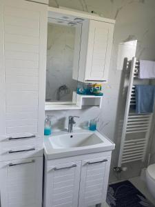 a white bathroom with a sink and a mirror at Murat villa in SJJ +21 photos