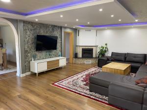 a living room with a couch and a tv at Murat villa in SJJ