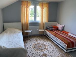 a bedroom with a bed and two tables in front of a window at Murat villa in SJJ