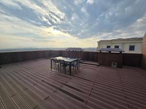 een terras met een tafel en stoelen op een dek bij Penthouse Nusha Apartments in Doesjanbe