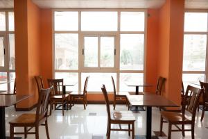 a restaurant with tables and chairs and windows at Smouha Hotel in Alexandria