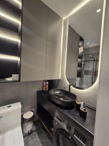 een badkamer met wastafel en wasmachine bij Penthouse Nusha Apartments in Doesjanbe