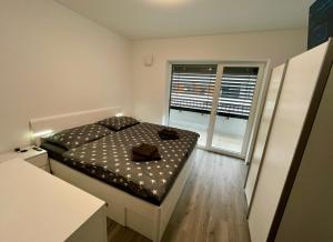 een kleine slaapkamer met een bed en een raam bij Apartmán Raj in Žilina