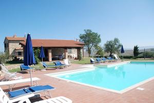 a swimming pool with lounge chairs and umbrellas at Agriturismo La Valle del Sole in Castiglione dʼOrcia
