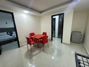 a red table and chairs in a room with a bed at Happy Beach Castel for Apartment قلعة شاطئ السعادة للشقق المفروشة in Aqaba