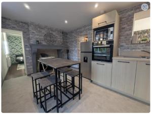 cocina con mesa, sillas y chimenea en O'bocolecha, en Orges