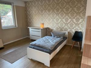 una camera da letto con un letto, una scrivania e una sedia di Cottbus Virchowstraße Zentrum a Cottbus Altre 17 foto