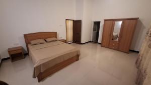 a bedroom with a bed and a wooden door at Villa Pilseli in Unawatuna