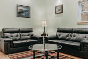 un soggiorno con divani in pelle nera e un tavolo di Glacier Springs #12 a Glacier
