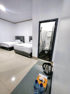 una stanza con due letti, uno specchio e due bottiglie d'acqua di Champrink Surfcamp a Wainapal Altre 2 foto