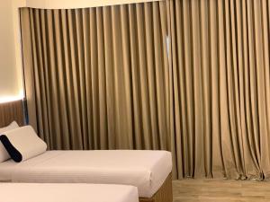 ein Hotelzimmer mit 2 Betten und Vorhängen in der Unterkunft فندق تمايا العاشر من رمضان in Madinat Al Ashir min Ramadan