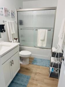 een badkamer met toilet en glazen douche bij Blue Mantle Charlotte Hideaway in Port Charlotte +13 foto's