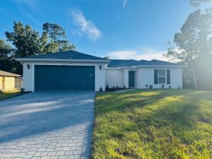 een wit huis met een garage bij Blue Mantle Charlotte Hideaway in Port Charlotte