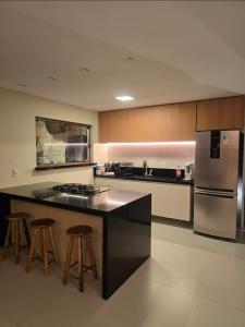 Maravilhosa Casa 5 Quartos-Reserva de Sauípe في كوستا دو ساويب: مطبخ مع ثلاجة وكاونتر مع الكراسي +38 صورة