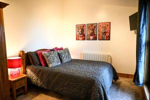 a bedroom with a bed and three paintings on the wall at Piglets Place in Hythe