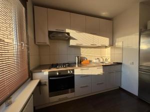 a kitchen with white cabinets and a stove top oven at Cietokšņa 64 in Daugavpils