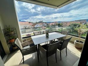 a dining room with a table and chairs and a large window at Apartment Zoe in Tivat