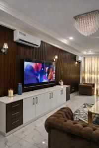 a living room with a flat screen tv on a wall at CHROME Résidences Fidjrossè PLAGE in Cotonou +36 photos