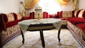 een woonkamer met een bank en een tafel bij Comfortable Apartment in Tangier 10 Min Stadium in Tanger