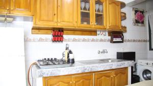 een keuken met houten kasten en een spoelbak bij Comfortable Apartment in Tangier 10 Min Stadium in Tanger +10 foto's