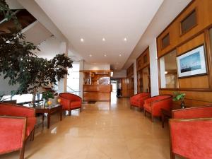 a dining room with red chairs and a table at Gran Lourdes Hotel in Villa Carlos Paz