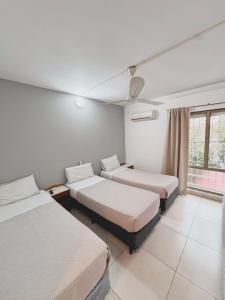 a hotel room with two beds and a window at Gran Lourdes Hotel in Villa Carlos Paz