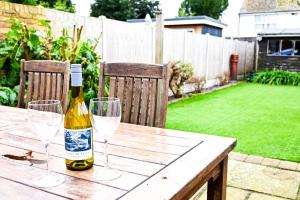 a bottle of wine sitting on a wooden table with glasses at The Walmer Retreat in Deal