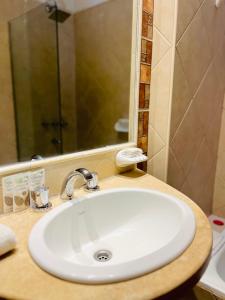 a bathroom with a sink and a shower at Gran Lourdes Hotel in Villa Carlos Paz