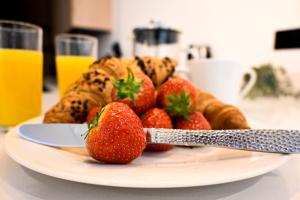 a plate of strawberries and croissants and orange juice at Laurie Grove in London +45 photos
