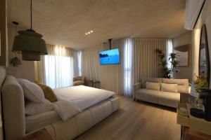a bedroom with a large white bed and a couch at Kohav Sea View Penthouse in Eilat