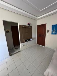 a living room with a large tile floor and two doors at Casa Fantástica in Guriri