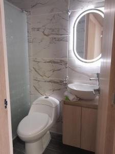a bathroom with a toilet and a sink and a mirror at La Casa De Mi Tatis in Salento