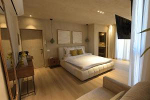 a bedroom with a large white bed and a desk at Kohav Sea View Penthouse in Eilat