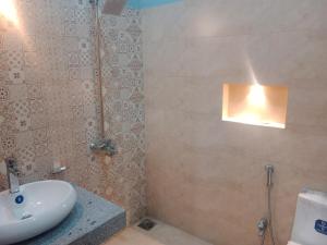 a bathroom with a sink and a shower at Bahria town karachi Volka Guest House in Karachi