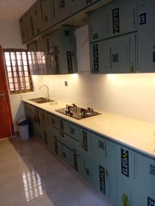a kitchen with boxes on the wall and a sink at Bahria town karachi Volka Guest House in Karachi