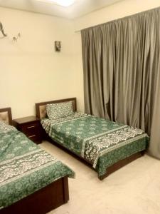 a room with two beds and a window at Bahria town karachi Volka Guest House in Karachi +5 photos